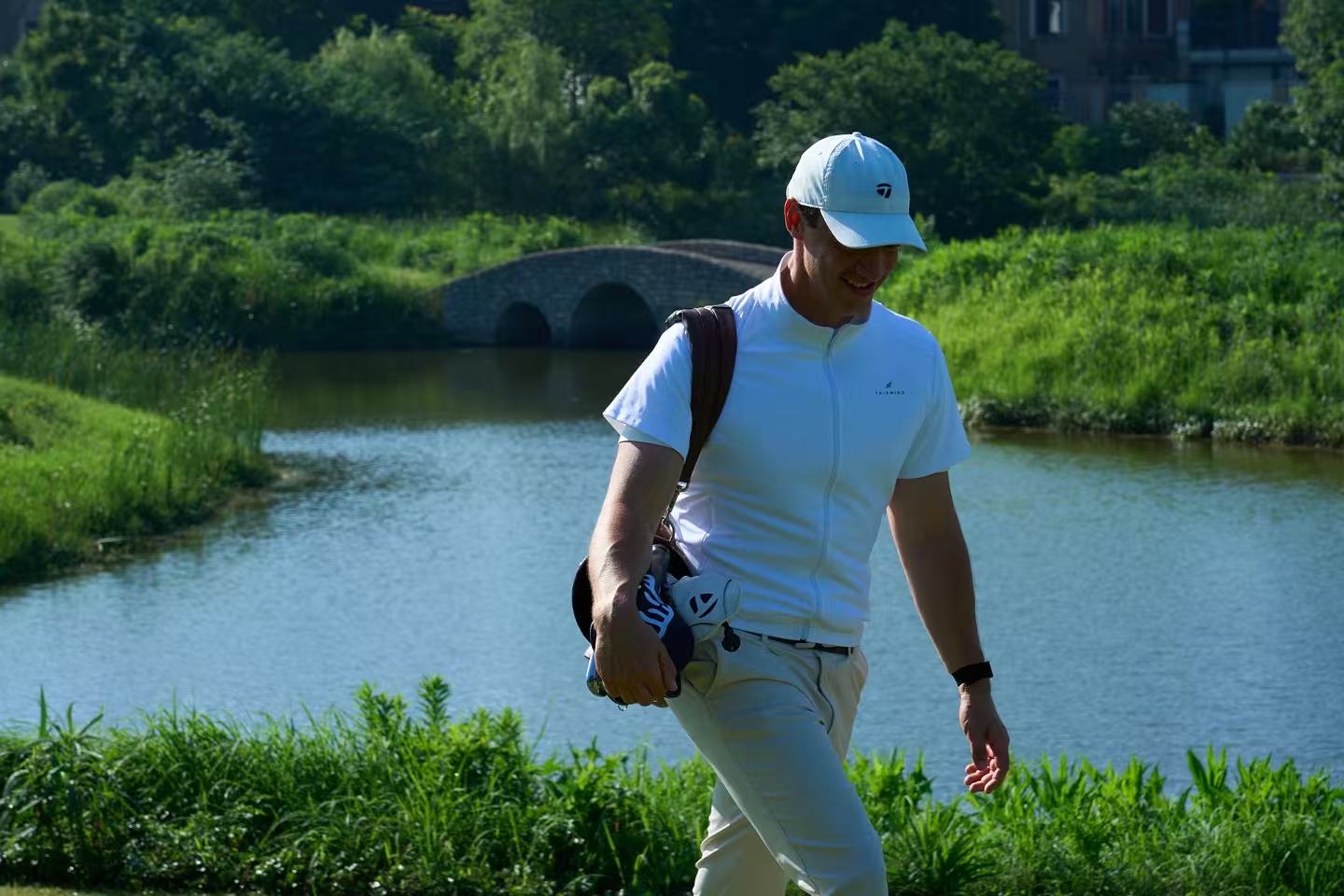 Golfer wearing Fairwind Flow walking between shots beside the lake